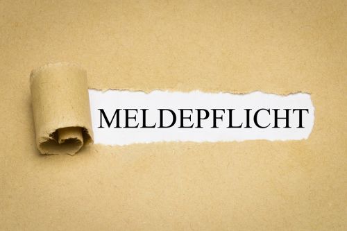 Foto: Aufgerissenes Papier mit Aufschrift Meldepflicht